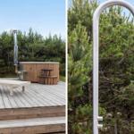 Outdoor terrace with hot tub, shower, and lounge chair. Surrounded by trees and grass.