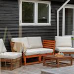 Terrace with table, chairs, umbrella, and grill. View of grassland and trees.