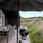Black playhouse with sandbox and colorful toys in the garden.