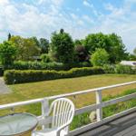 Deck with grill, seating, and view of green surroundings.