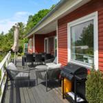 Terrace with seating group, table, and umbrella. View of green landscape.