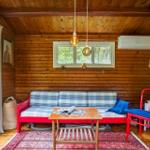 Bedroom with wooden walls, bed, TV, and view of garden.
