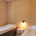 Bedroom with wooden walls, bed, and window with view of greenery.