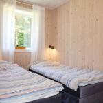 Bedroom with wooden walls, wardrobe, and view into bathroom and living area.