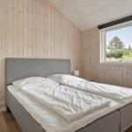 Bedroom with bed, window, and wood paneling.