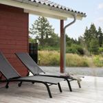 Sauna with wooden walls and bench, beside bucket with brush.