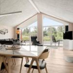 Dining room with wooden walls, dining table, and wood stove. Wall art of a vehicle.